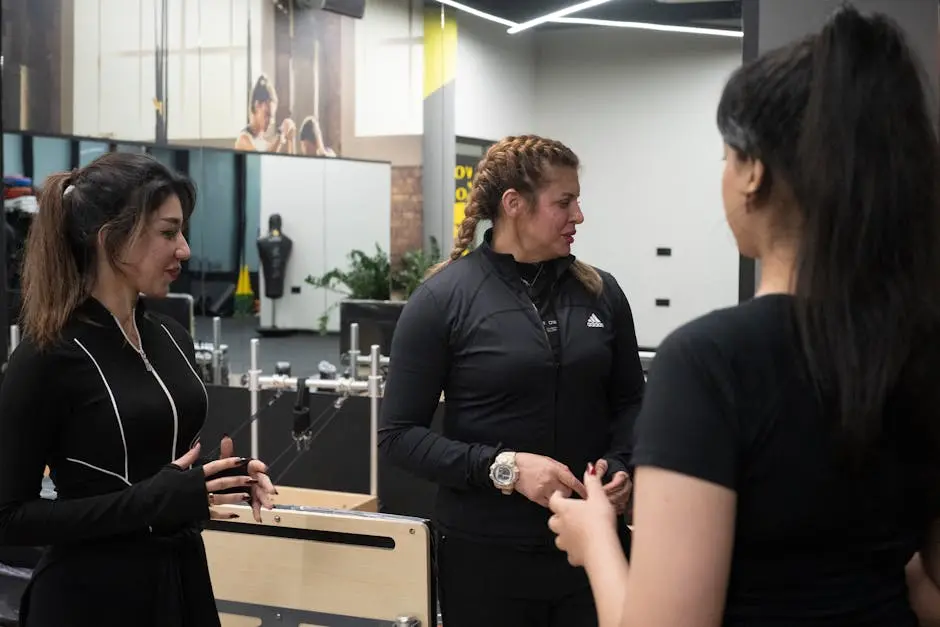 Three women in a modern gym having a conversation. Fitness and wellness theme.