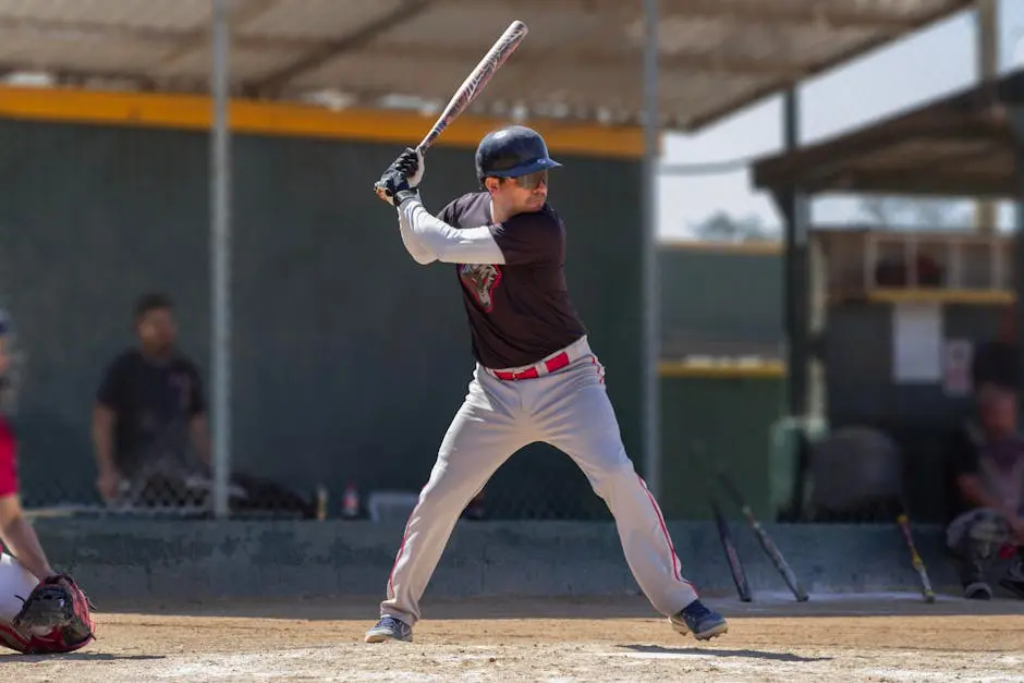 Baseball player in action, poised to swing during a sunny game outdoors.
