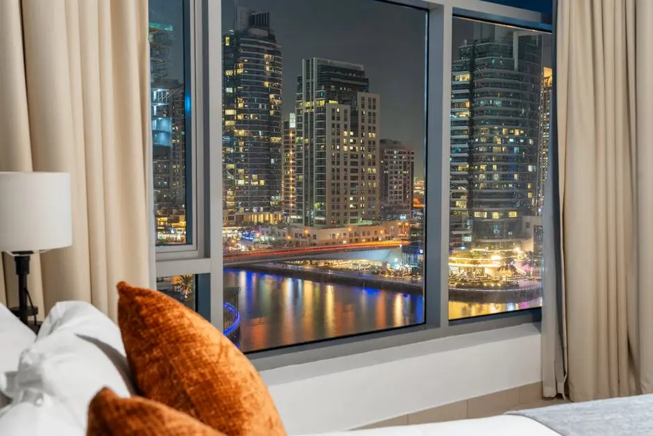 An elegant view of Dubai Marina&rsquo;s night skyline through a luxurious hotel window.