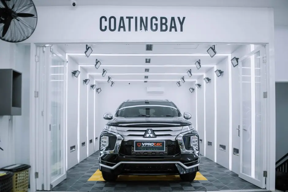 A sleek Mitsubishi SUV inside a modern automotive coating facility.