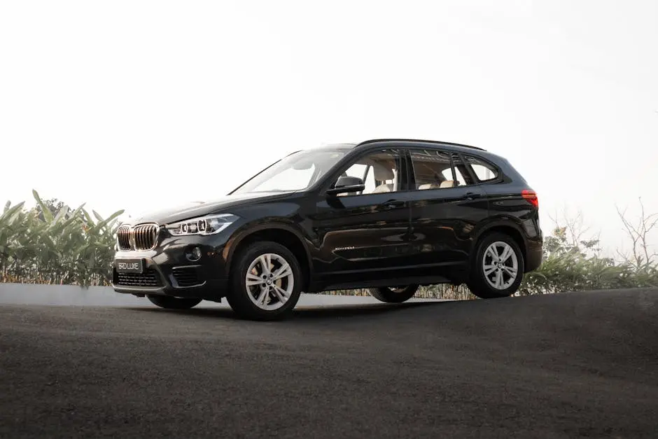 Sleek black SUV in a parking lot with clear skies, showcasing luxury and style.