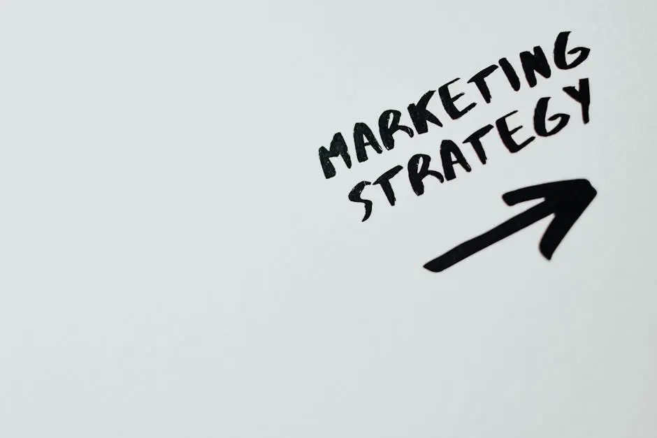 Close-up of handwritten ‘Marketing Strategy’ text with an arrow on white background.