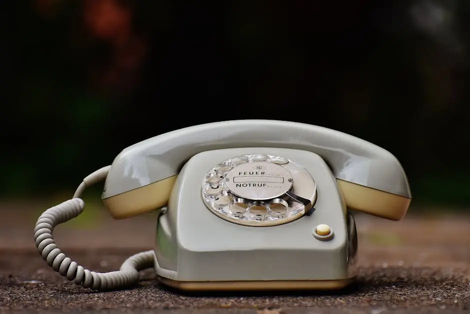 Close-up of a vintage rotary dial telephone with a nostalgic design on a wooden surface.