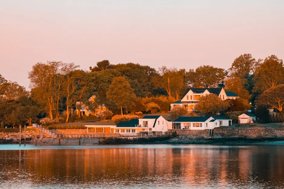 Lakeside view of homes surrounded by trees during a tranquil sunset in Stamford, CT.