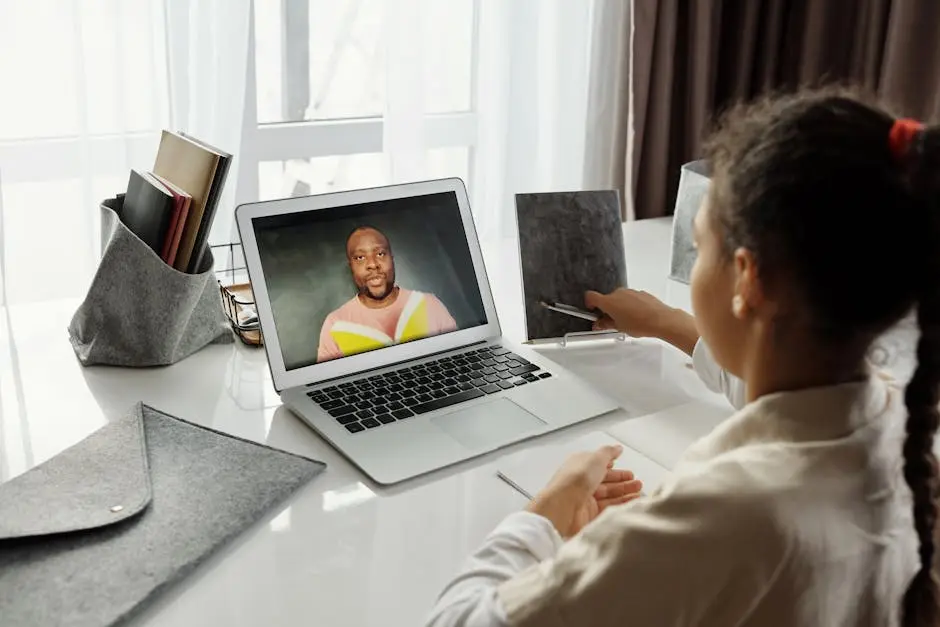 A young girl participates in an interactive online class with a teacher on a laptop, fostering education from home.