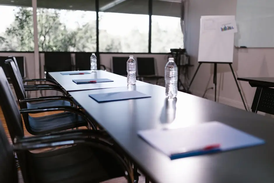 Spacious conference room with water bottles and notes on a wooden table ready for a meeting.