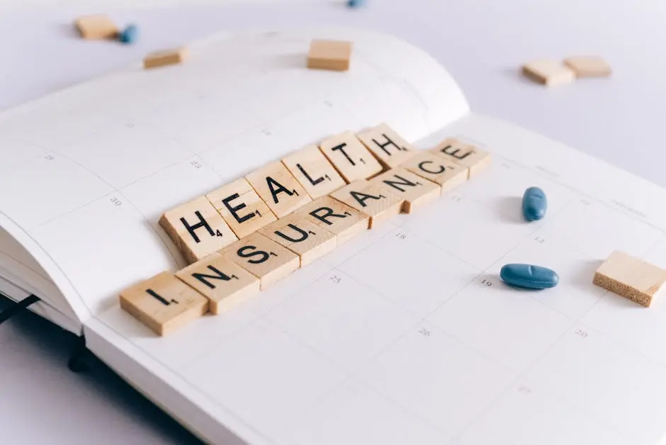 Scrabble tiles spelling ‘Health Insurance’ on a calendar with pills.
