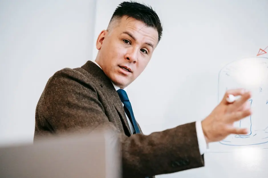 A professional lecturer in formal attire explaining a concept on a whiteboard during an online class session.