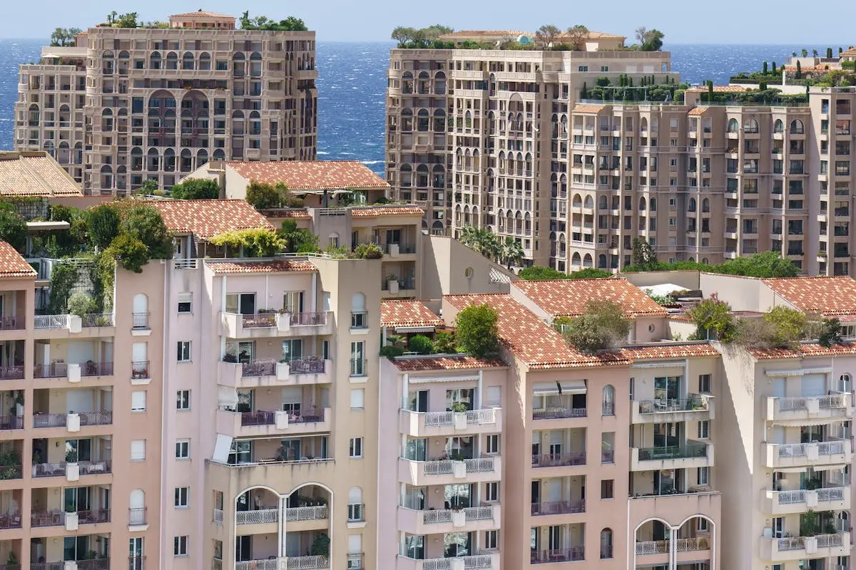 Panoramic view of luxury Mediterranean-style apartments in Monaco, with a backdrop of the blue sea.