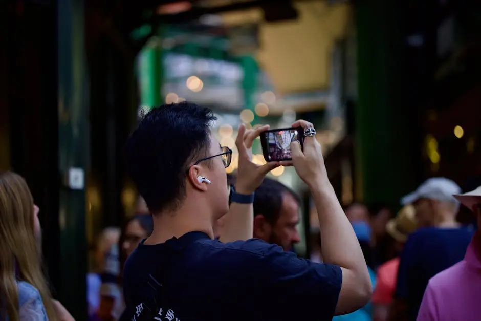 A man photographs the bustling atmosphere at London’s Borough Market, a famous urban food destination.