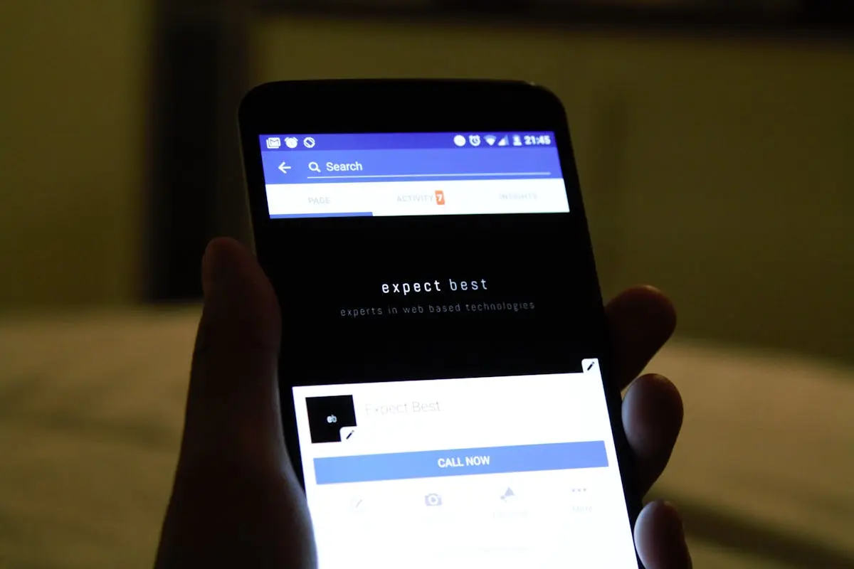 Close-up of a hand holding a smartphone showing a social media application screen.