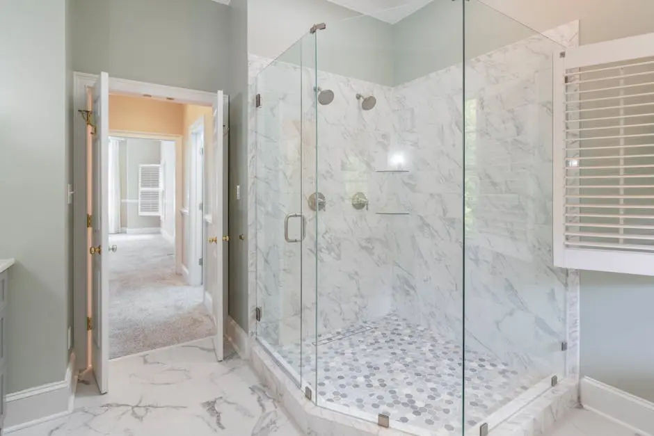 Spacious luxury bathroom featuring a contemporary marble shower with glass doors and elegant interior design.