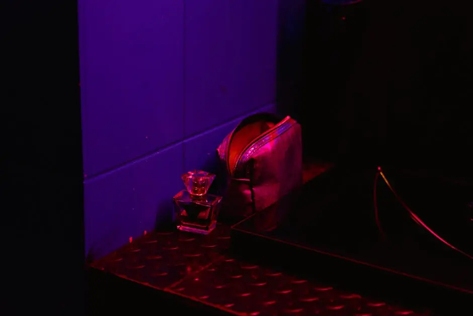 A shot glass and purse illuminated by vibrant nightclub lighting.