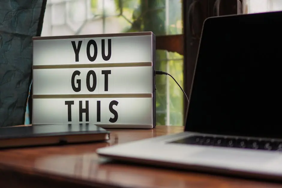 Lit sign with ‘You Got This’ alongside laptop on office desk.