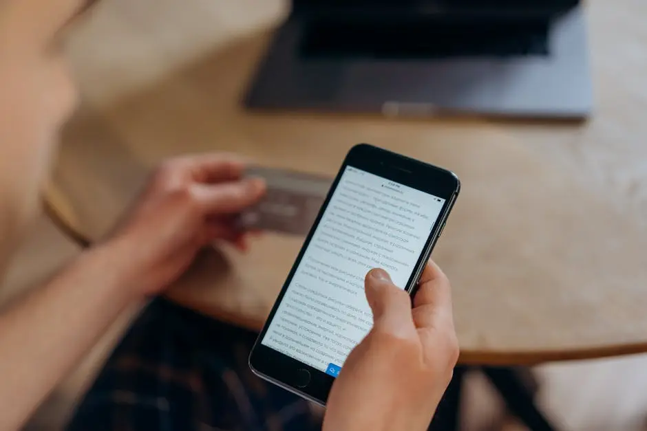 Close-up of a person holding a smartphone and credit card. Ideal for online shopping concepts.