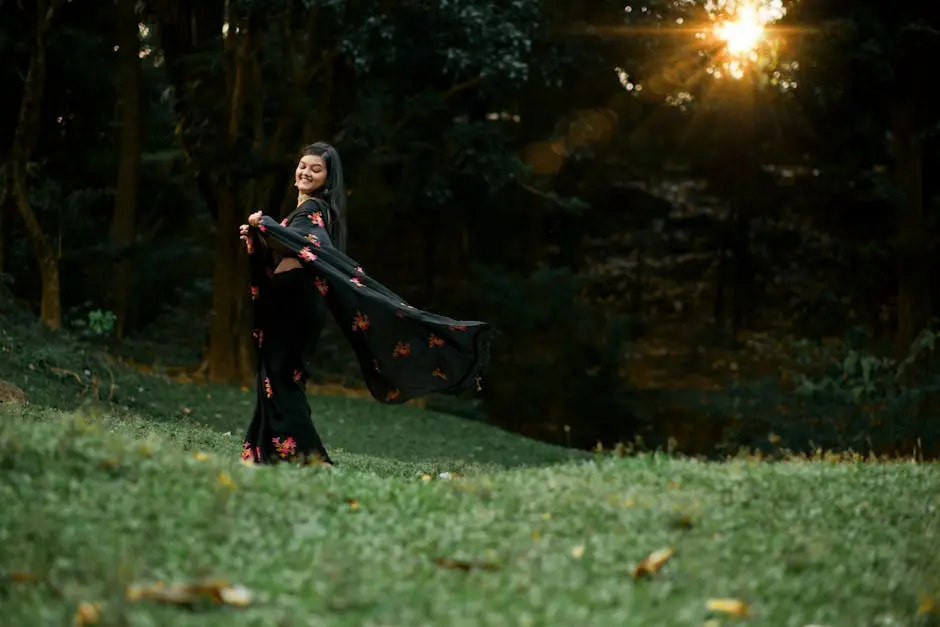 A woman twirls joyfully in a sunlit forest, wearing a floral black dress.