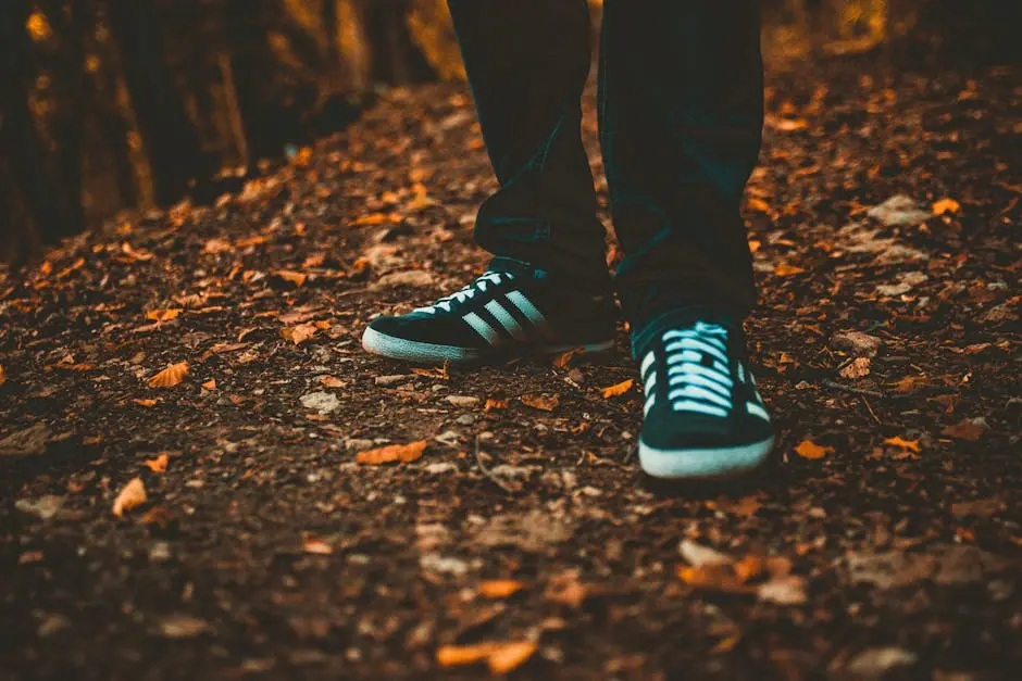 Close-up of sneakers on a leaf-strewn path, capturing the essence of fall outdoors.