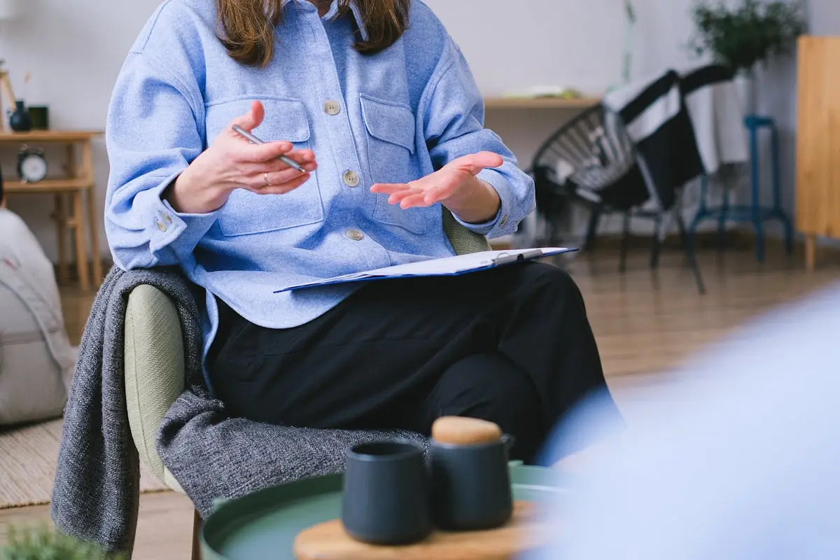 A therapist consults with a client in a contemporary office, focusing on mental health.