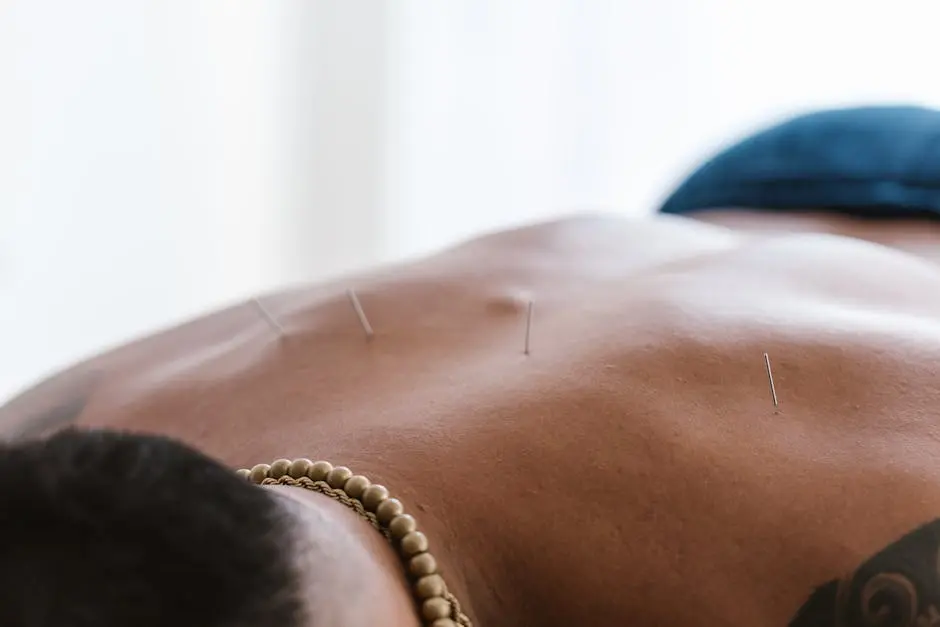 Close-up of acupuncture needles on a person’s back during a therapy session in a spa setting.
