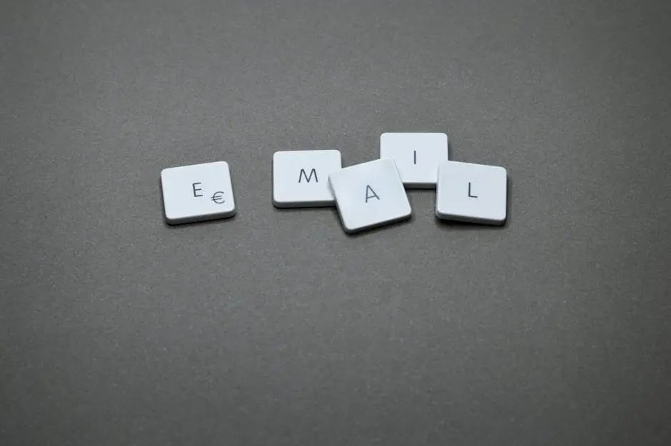 Close-up of the word &lsquo;email&rsquo; formed with letter tiles on a gray surface.