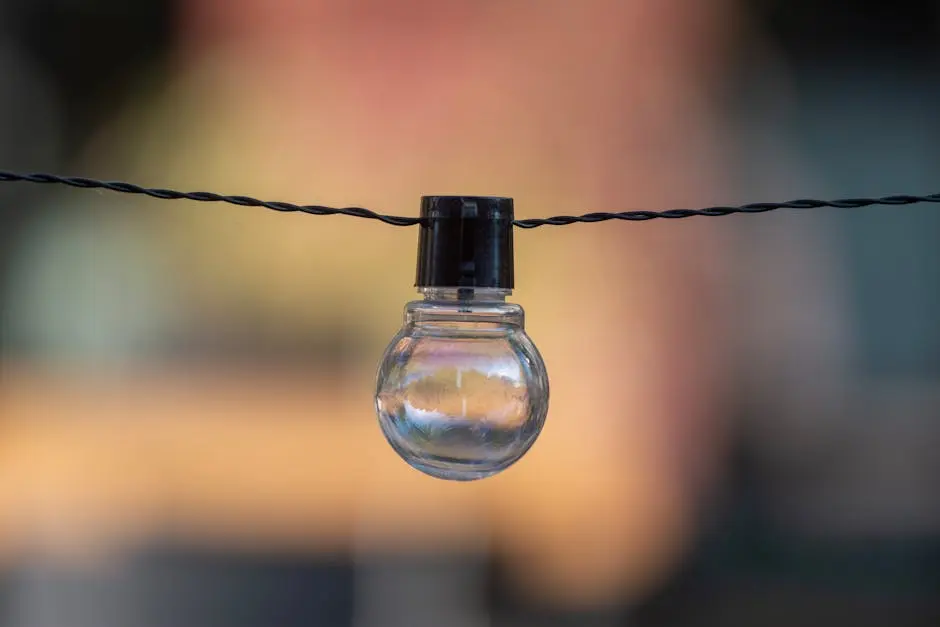 A close-up of a decorative outdoor string light bulb with a blurred background.