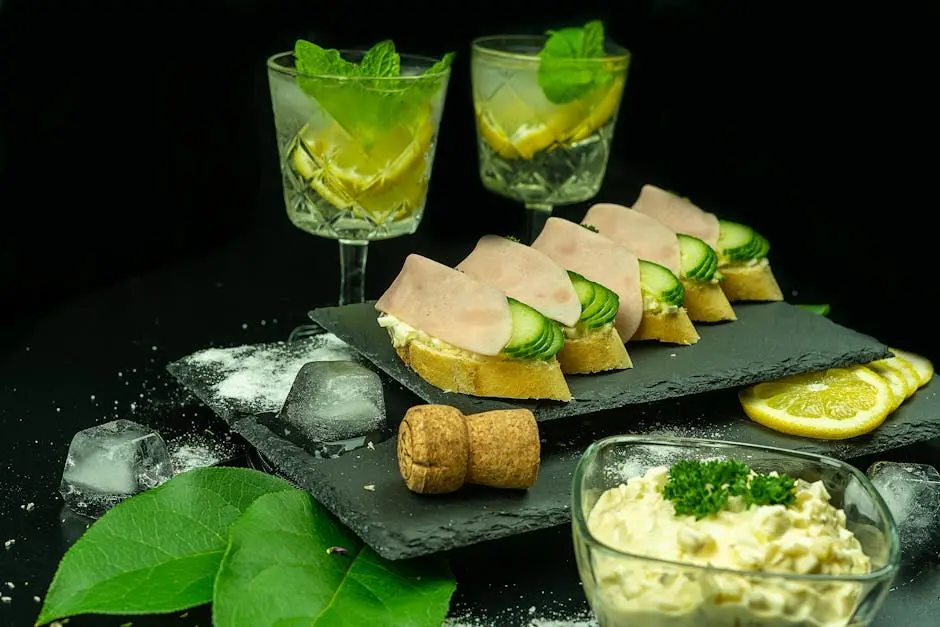 A stylish setup of cocktails and finger food garnished with fresh ingredients, perfect for parties.