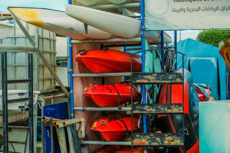 Vivid red and orange kayaks neatly stacked on metallic racks in an outdoor storage area.