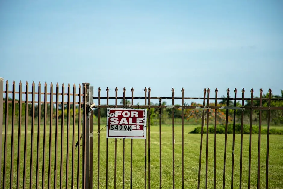 A large plot of land bordered by an iron fence, complete with a ‘For Sale’ sign in Miami, FL. Ideal for development.