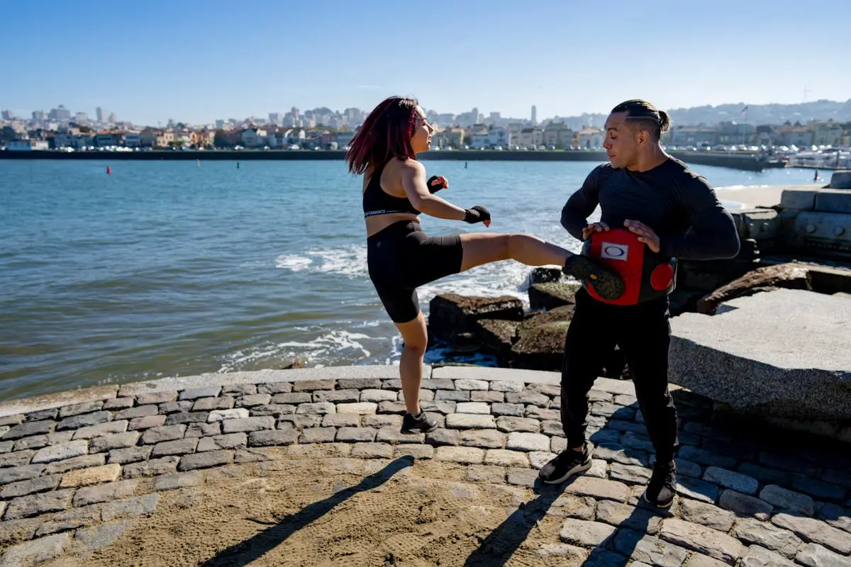 Martial arts enthusiasts practicing kickboxing with scenic San Francisco Bay backdrop on a sunny day.