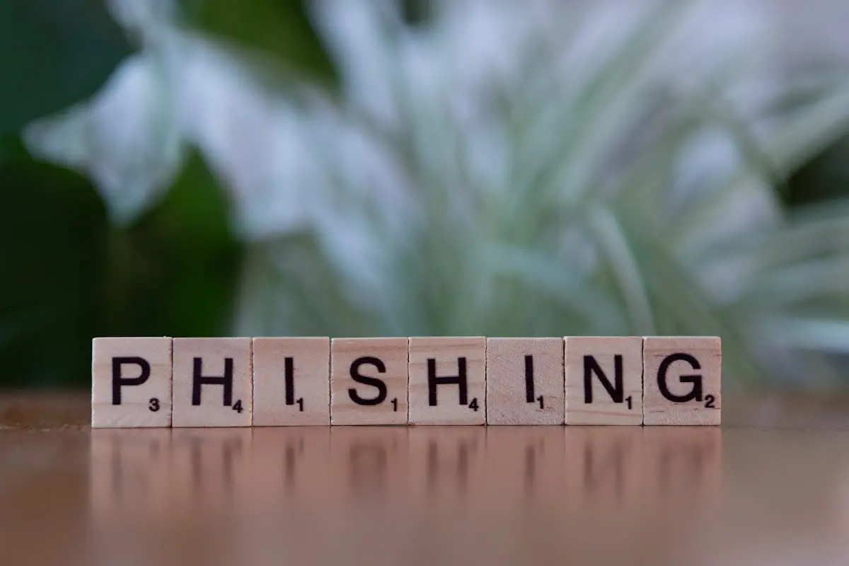 Wooden tiles spelling &lsquo;phishing&rsquo; highlight cybersecurity themes.
