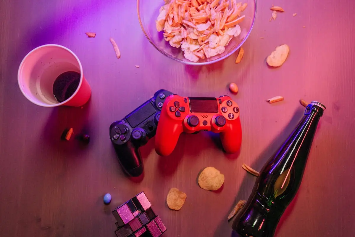 Messy Table with Game Controllers and a Beer Bottle