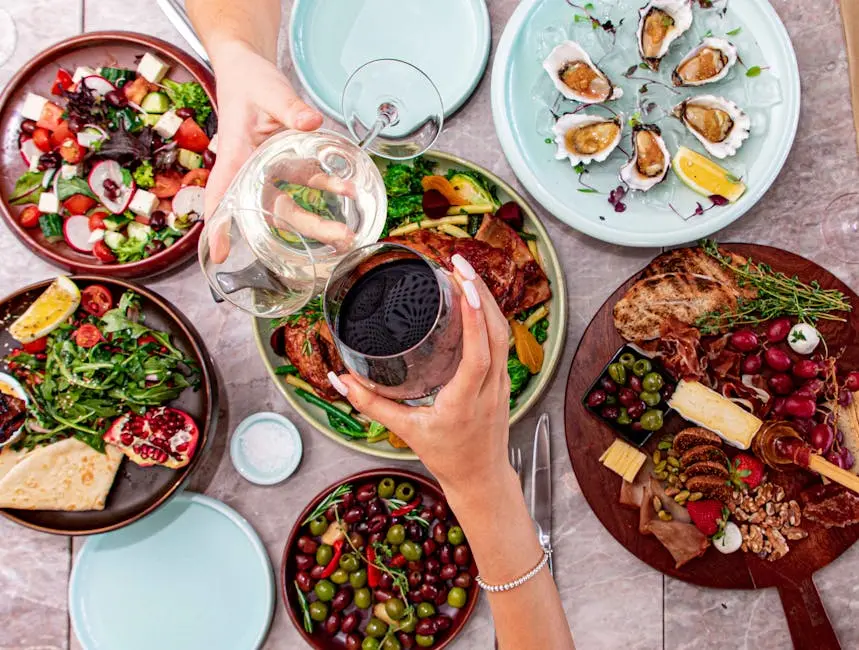 A top view of a luxurious dining setup featuring gourmet dishes, fresh salads, oysters, and wine.
