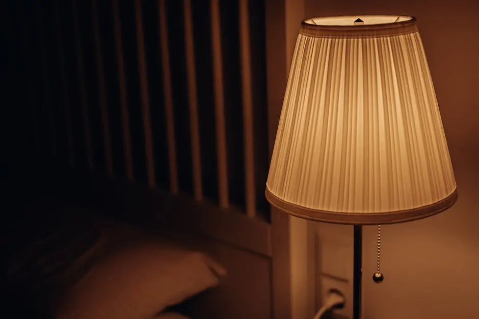 A dimly lit bedside lamp creating a warm and cozy atmosphere in a bedroom setting.