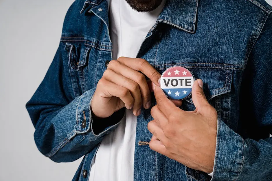Close-up of a person pinning a vote badge on a denim jacket, symbolizing democracy and civic engagement.