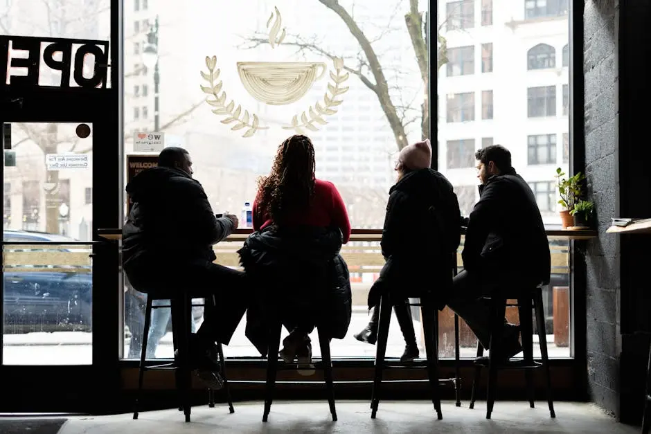 Friends enjoying a cozy afternoon in a Detroit café, seated by the window.