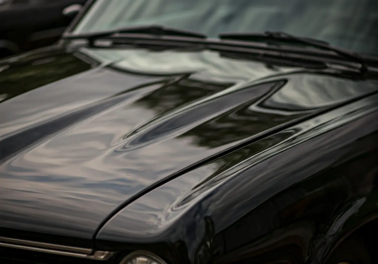 A close-up of a shiny, polished black car hood. 35mm stock photo