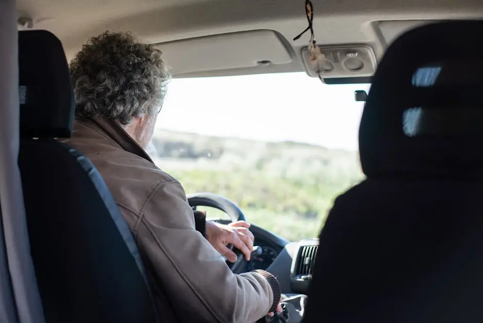 A senior man drives a motorhome through picturesque Portuguese countryside, highlighting travel and adventure.