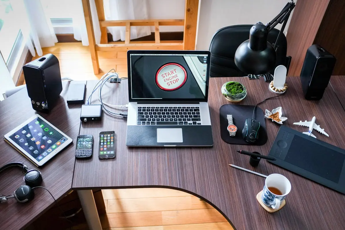A contemporary office desk setup with laptops, gadgets, and accessories, creating a tech-savvy workplace.