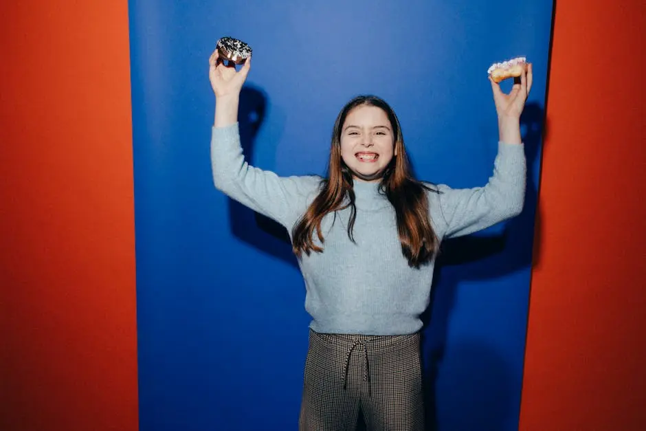 A smiling girl happily holds donuts against a colorful backdrop, expressing fun and joy.