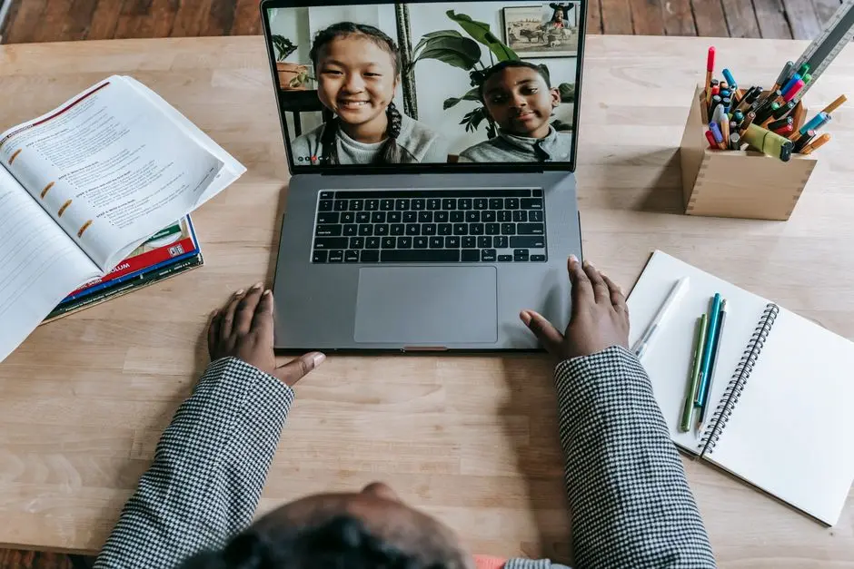 Crop anonymous clever African American female talking with pupils about plan of homework online on laptop