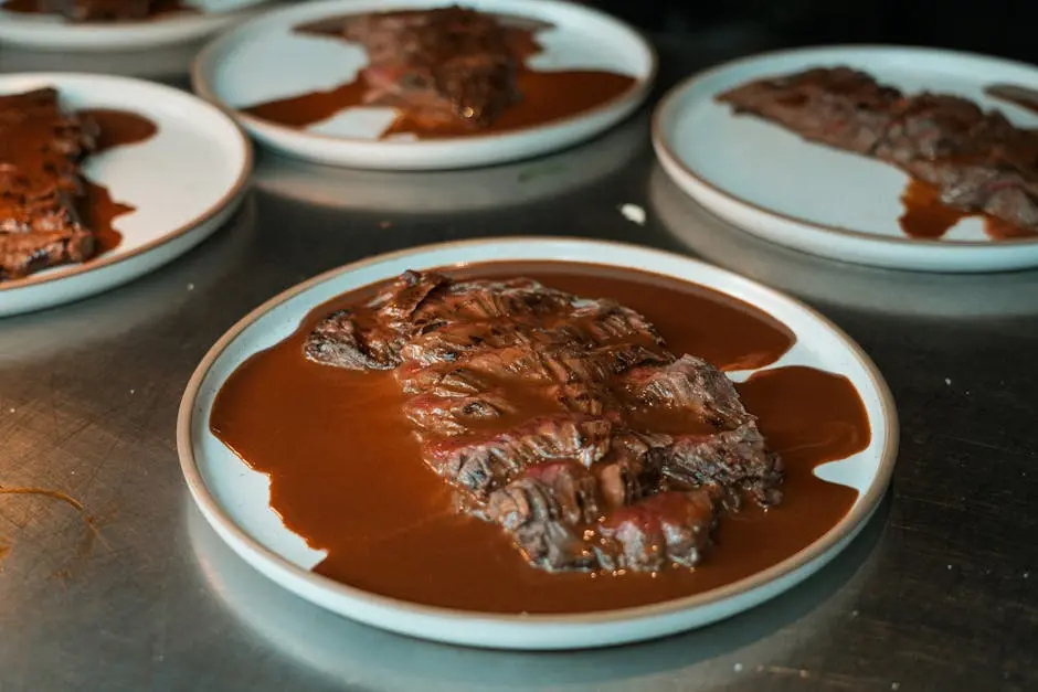 Deliciously cooked sliced picanha served with rich barbecue sauce on white plates, perfect for gourmet dining.