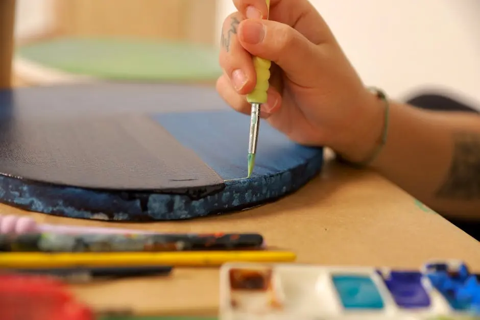 Artistic close-up of a hand painting a canvas with watercolors, highlighting creativity.