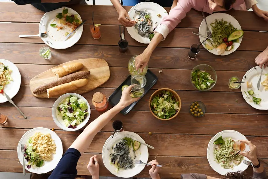 An overhead shot of a dining table featuring various pasta dishes and salads shared by a group.
