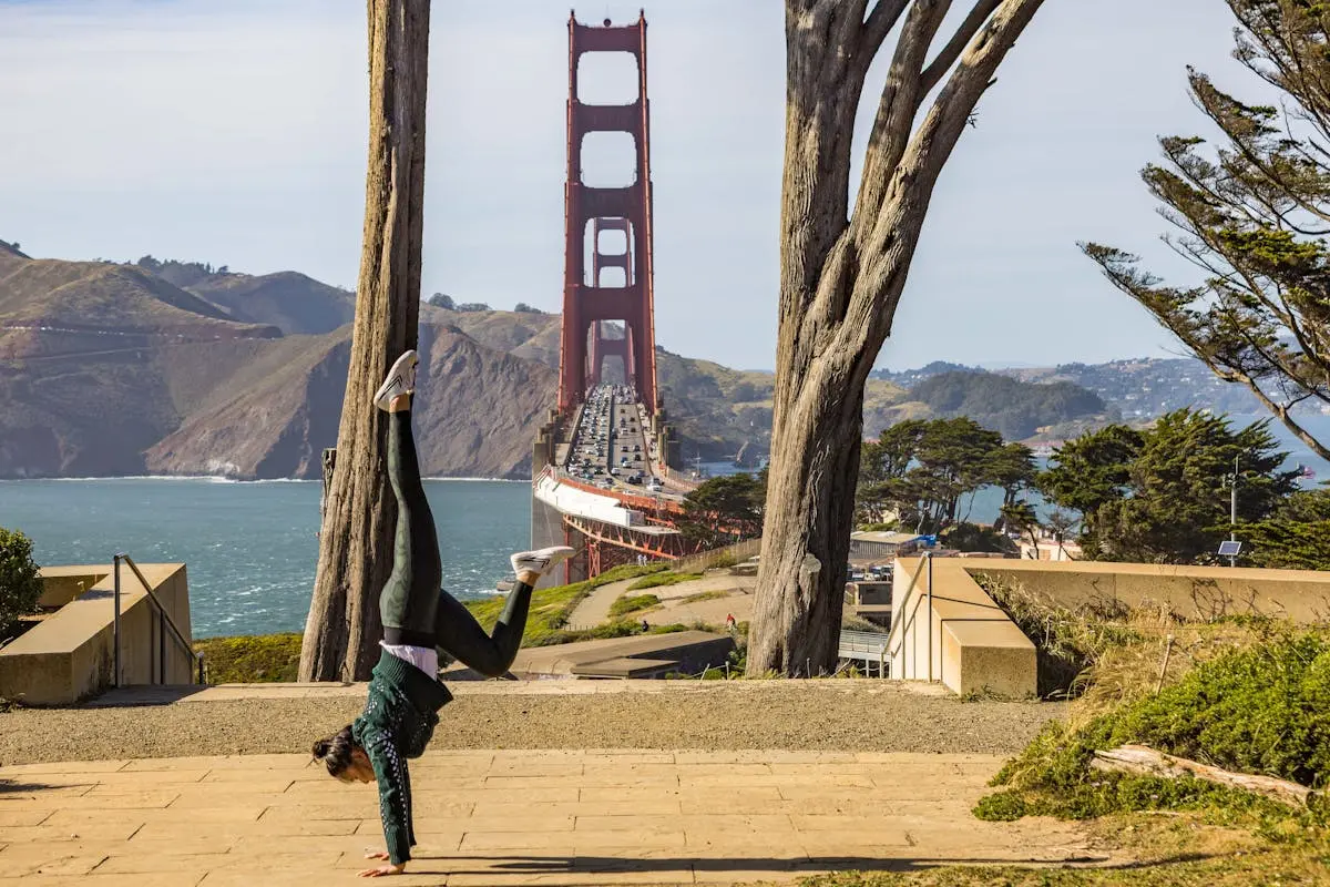 Woman in handstand with Golden Gate Bridge in background, San Francisco.