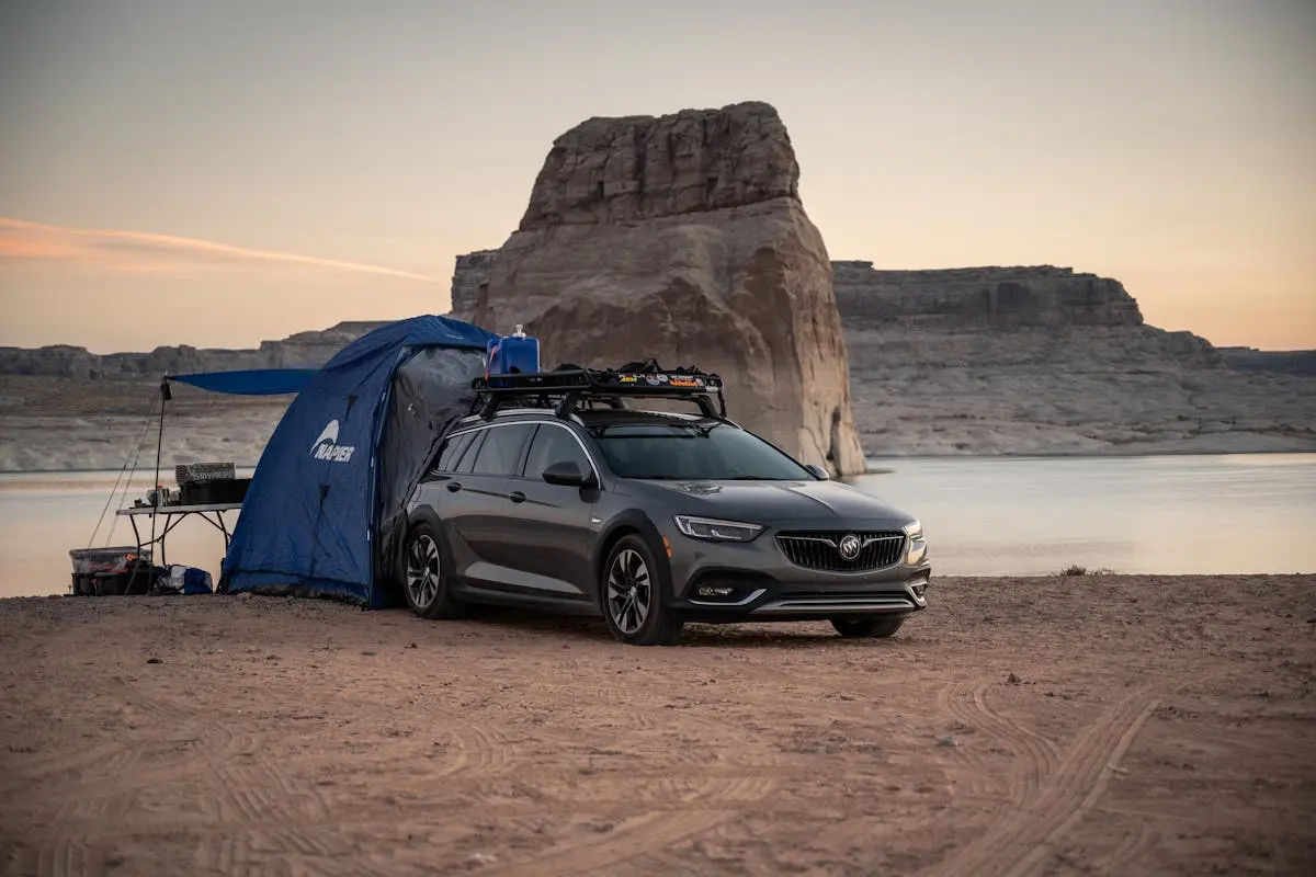 A car parked beside a tent at Lake Powell, perfect for a desert camping experience.