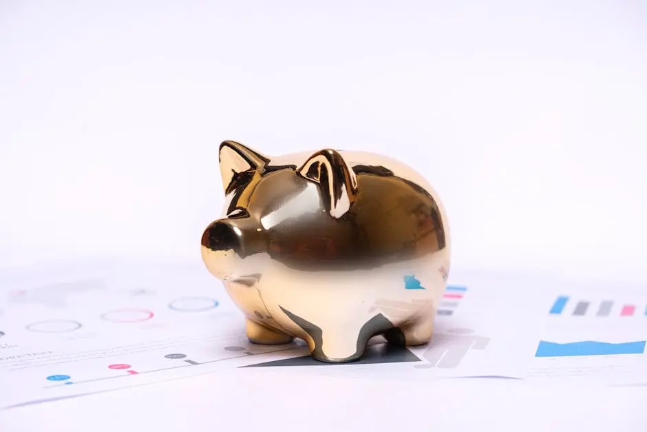 Close-up of a golden piggy bank on financial documents, symbolizing savings and investment.