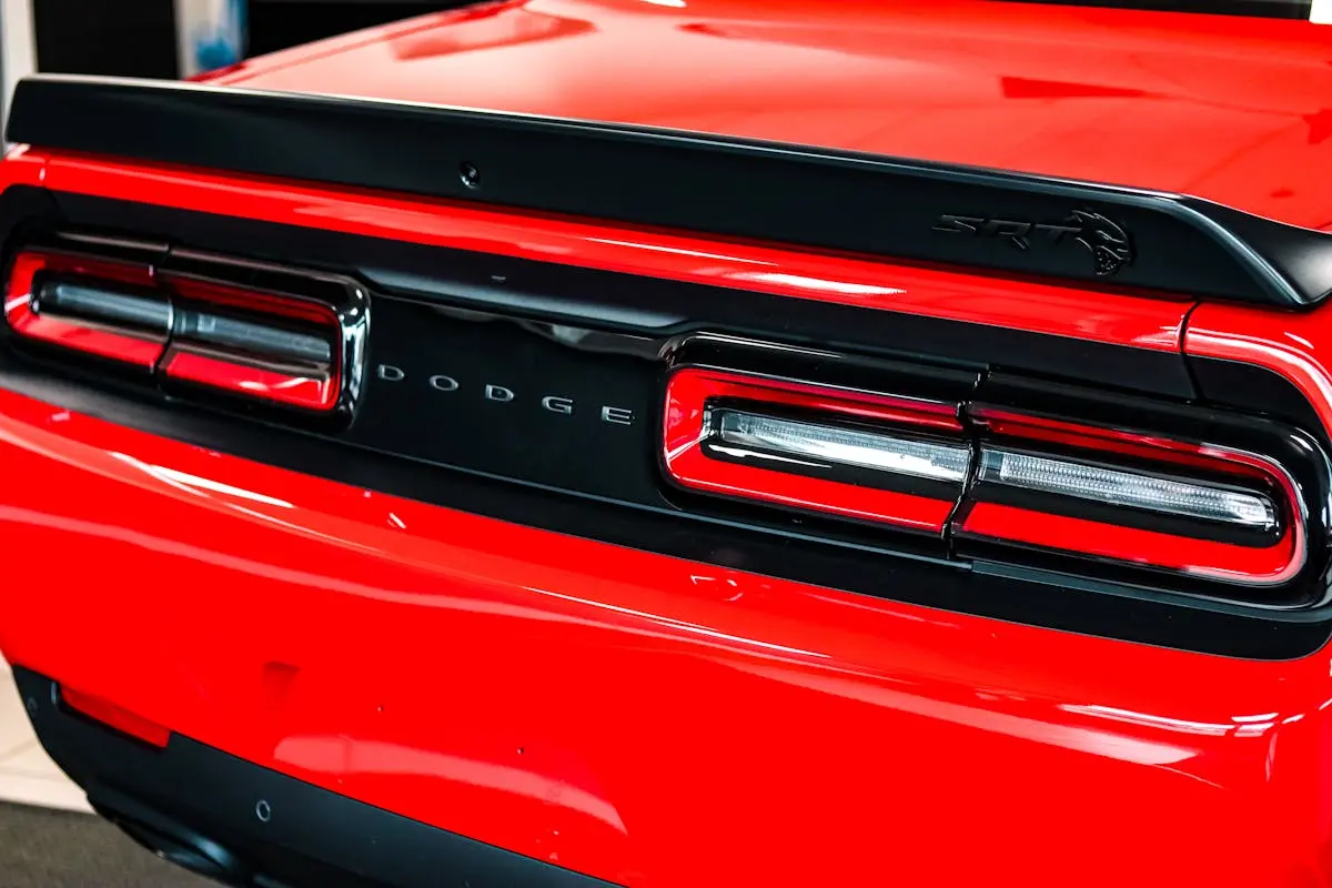 Detailed view of a red Dodge Challenger’s taillights, emphasizing sleek design.