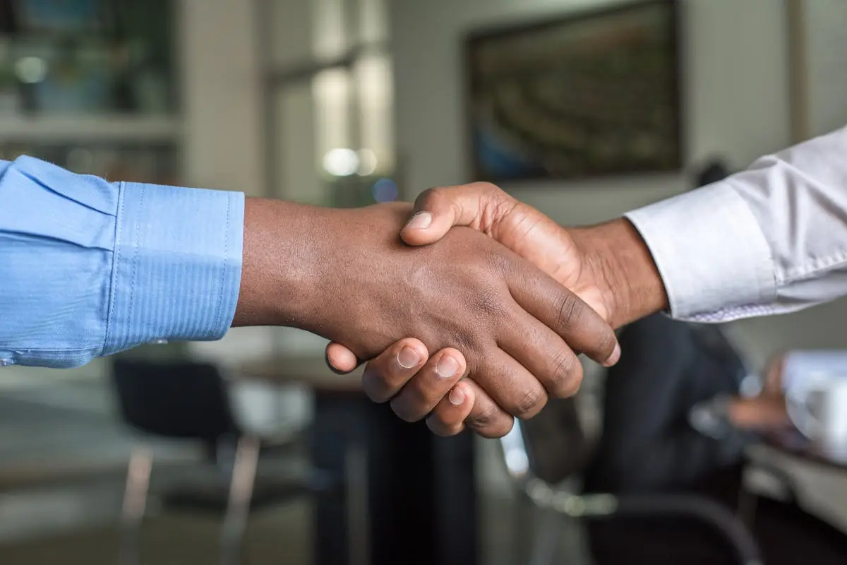 Close-up of two men’s handshake symbolizing agreement in an office.