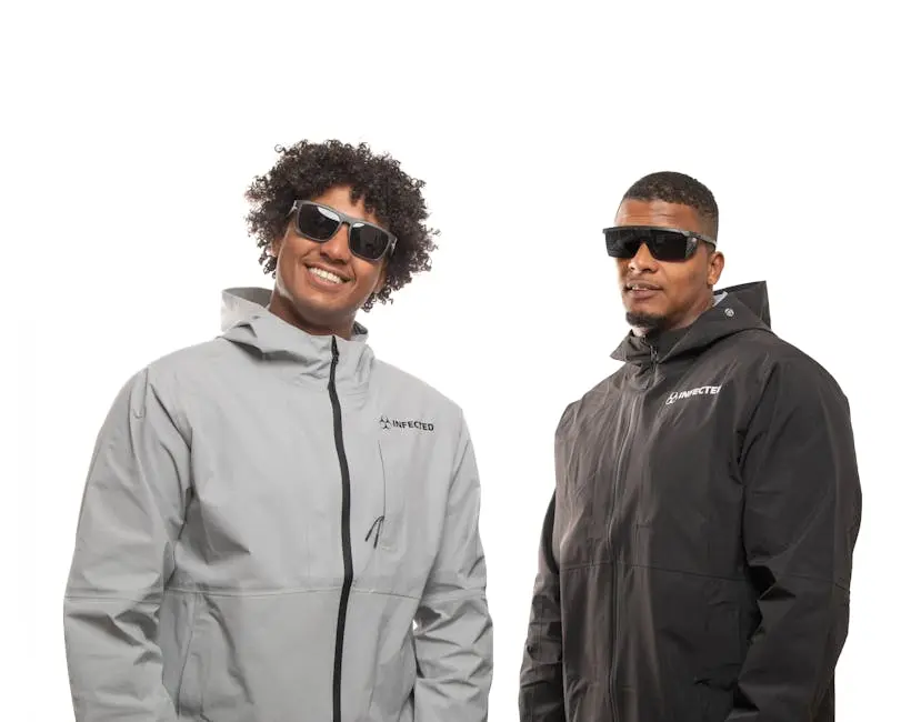 Two men in trendy jackets and sunglasses posing confidently against a white background.