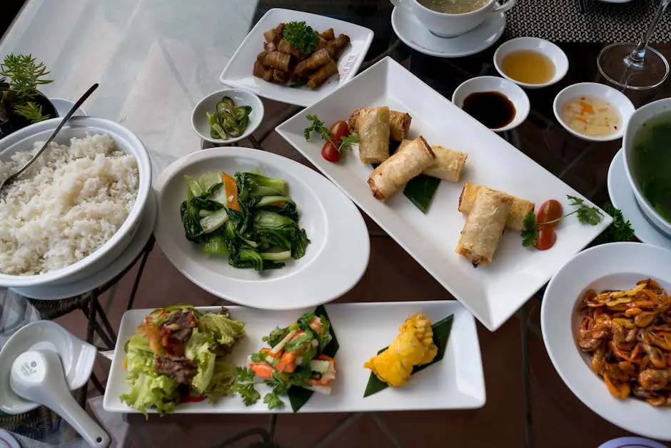 A colorful spread of Vietnamese dishes including rice, vegetables, and spring rolls.